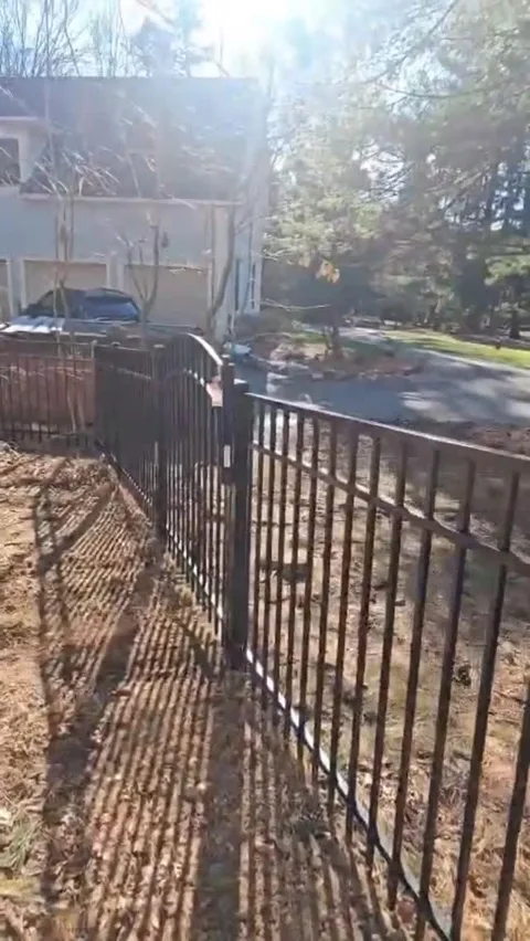 Black aluminum fence following a driveway in New Jersey